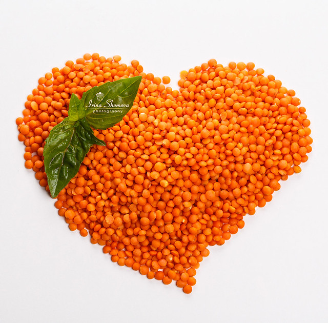 Lentils in the shape of a Heart  with basil isolated on white background
