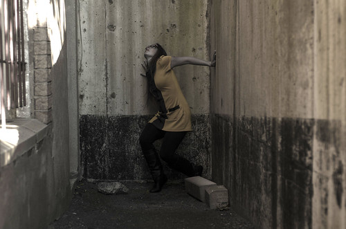 52project 52weeksofphotography 3752 nikon 50mm d7000 2013inphotos selfportrait portrait woman lady redhair boots leggings longhair strength glasses running cornered stuck cement walls lookingup lookingforawayout dress crouch yellow desaturated rough grit flashfix flashfixphotography