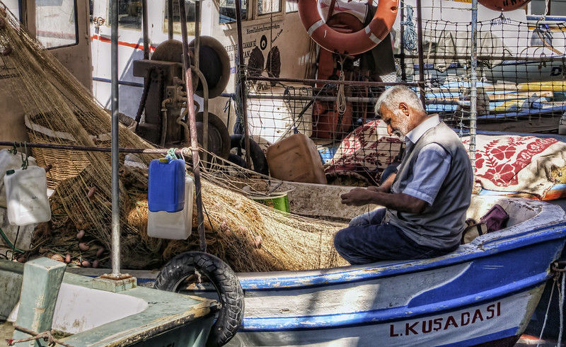 A fisherman repairs his nets in Kusadasi, Turkey