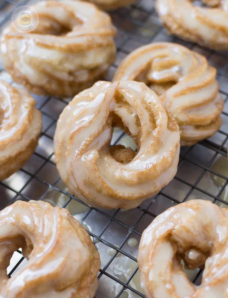 close up of French honey crullers showing shiny glaze on wire rack