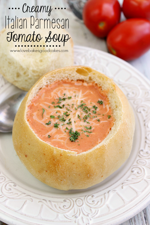 {Slow Cooker} Creamy Italian Parmesan Tomato Soup in a bread bowl on a plate with a spoon.