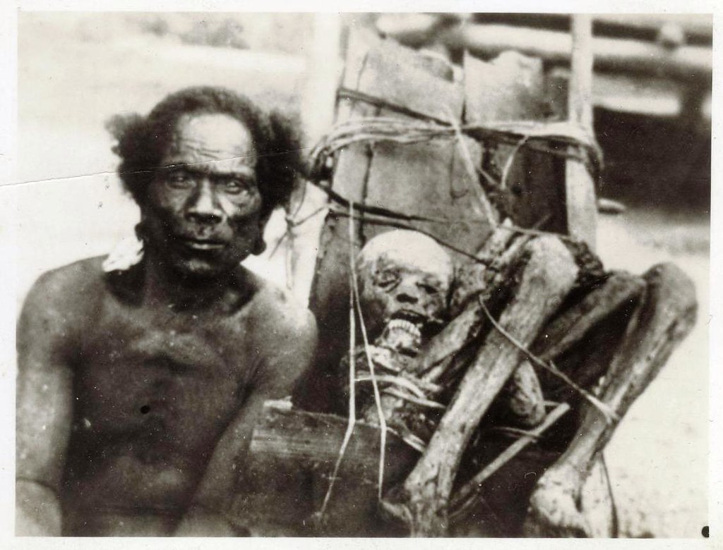 New Guinea native posing with a mummified body - WW2 era