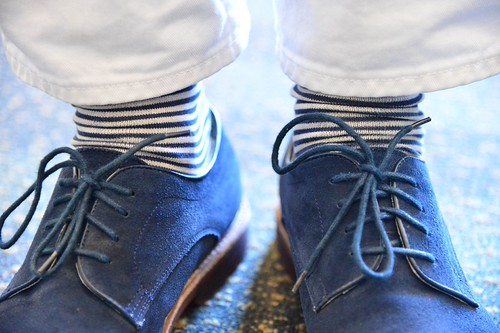 piedi maschili che indossano scarpe di camoscio blu e calzini a righe bianche e blu