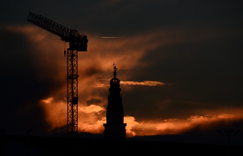 sunset silhouettes grue contrejour orangé beffroi soleilcouchant cielchargé