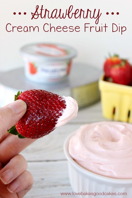 Strawberry Cream Cheese Fruit Dip on a fresh strawberry with a bowl of dip.