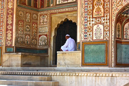 a man seated at the palace entrance