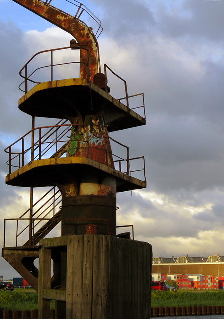 A spiral staircase leading up to a rusted crane in NDSM, an industrial area across the river from Amsterdam