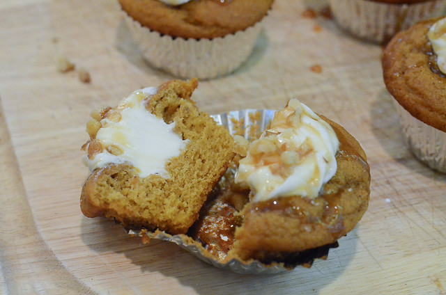A cupcake is cut in half to reveal its cream cheese filling.
