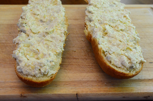 The mixture is spread across a loaf of french bread.