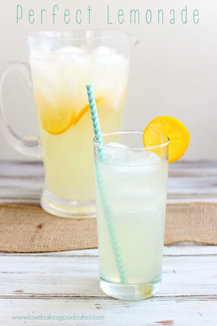 Perfect Lemonade in a glass pitcher, and a glass with lemon slices and ice cubes.