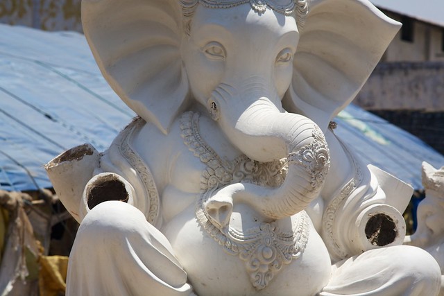 A clay Ganesha statue on the side of the road which will be painted and used in an upcoming festival