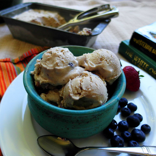 3 scoops of Fruit Dip Ice Cream in a blue ice cream bowl with fresh blueberries and one strawberry on the side.