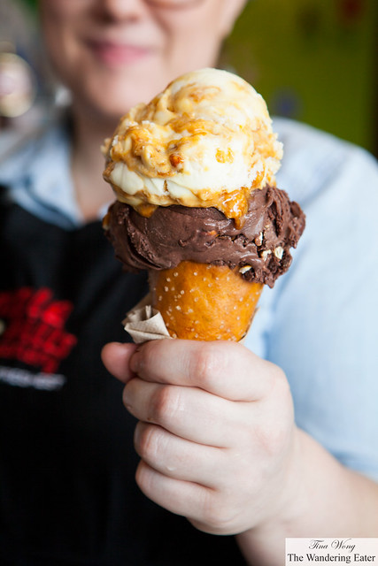 Amy of Ample Hills holding the pretzel cone topped with Chocolate, Pretzel & Stout and "Sweet as Honey" ice creams