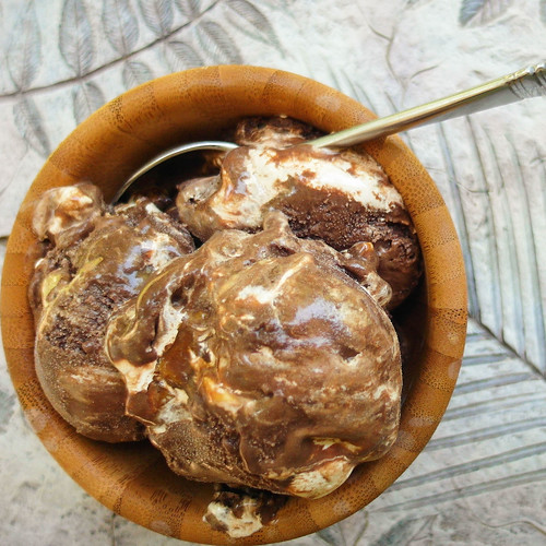 Triple Chocolate Coffee Peanut Crunch Gelato scoops in a wooden bowl with a metal spoon.