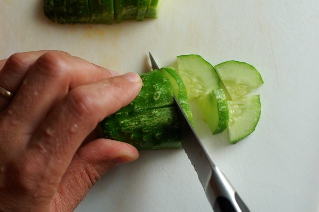 Slicing a fresh-picked cucumber by Eve Fox, The Garden of Eating, copyright 2014