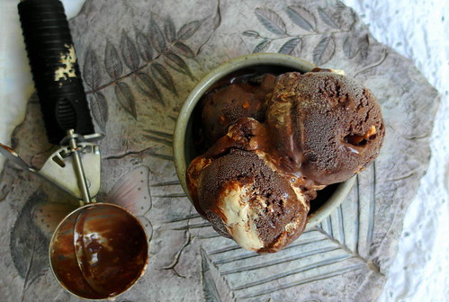 Triple Chocolate Coffee Peanut Crunch Gelato scoops in a single serve bowl with an ice cream scoop to the side. 