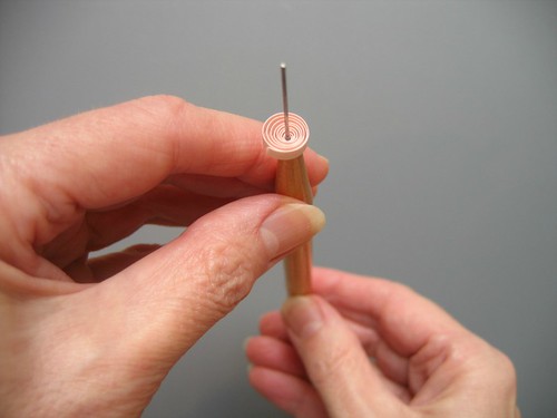 hands holding quilled loose coil on needle tool