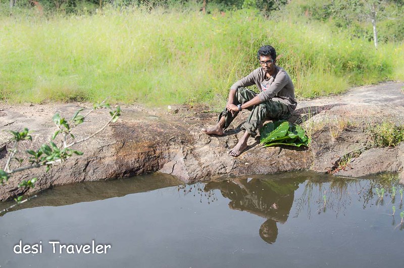 An Eco Volunteer rests next to water hole Bandipur