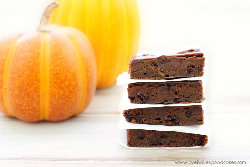 Pumpkin Brownies stacked up with two pumpkins.