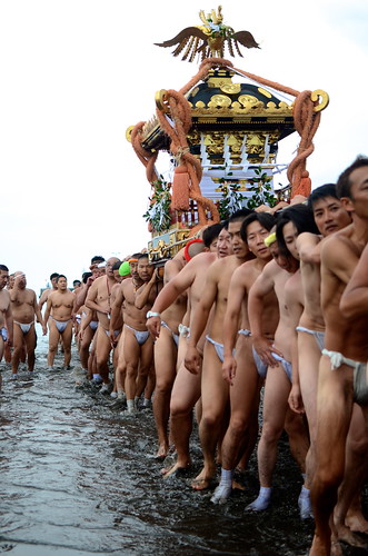 Local residents carrying their mikoshi into the sea at a festival in Enoshima