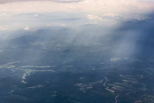 trees light sunlight mist mountains alps window field misty clouds forest plane airplane landscape europe ray flight continental aerial farmland roads peaks agriculture