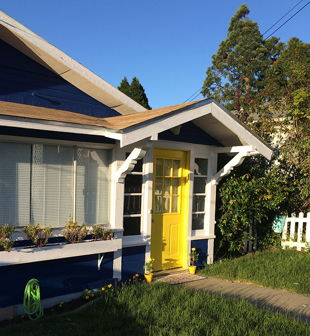 cute blue and yellow house, green lawn, white picket fence
