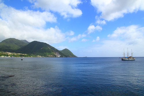 blue sea sky mountains water clouds boat line shore dominica roseau carbbean