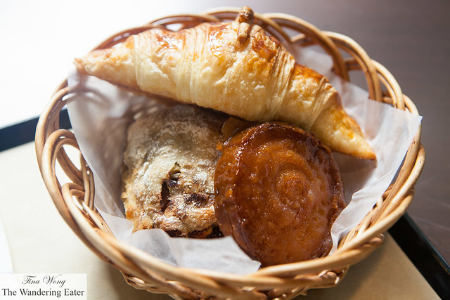 Basket filled with olive roll, kouig amann, and croissant