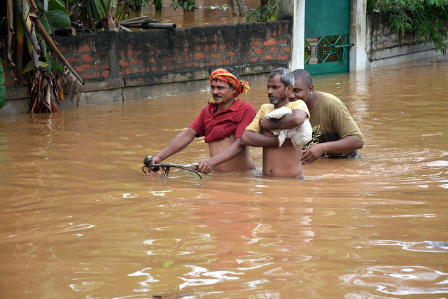 People make their way in flood in Guwahati.