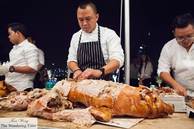 Chef Neil Syham slicing the lechon (spit roast suckling pig) and Chef Dale Talde on the right
