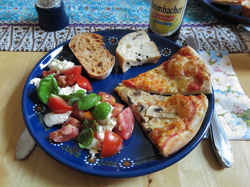 Pizza Funghi, Pizza Margherita, Olivenbrot und Tomatenbrot zu Mozzarella-Tomaten-Salat
