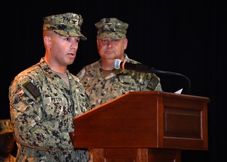 Capt. David “Lee” Petty reads his orders during his change of command ceremony June 23, 2014 at Naval Support Activity in Bahrain. In a change of command ceremony, Petty relieved Capt. Robert Hendrickson as commodore of Coast Guard Patrol Forces Southwest Asia. U.S. Navy photo by Naval Support Activity Bahrain Public Affairs Office.