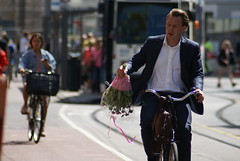 Student met een bosje bloemen op fiets
