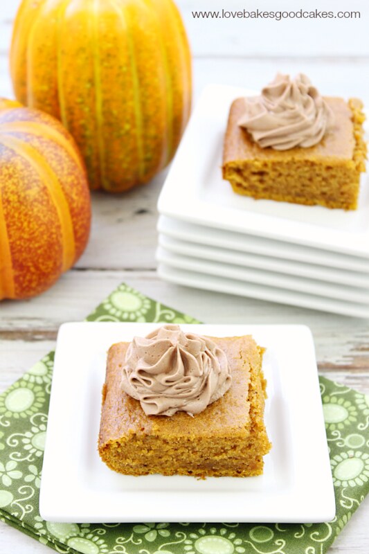 Pumpkin Bars with Nutella Buttercream Frosting on white plates with pumpkins.