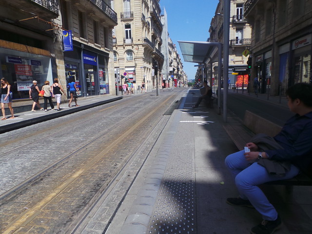 son waiting for the tram in Bordeaux