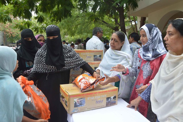 Shujath Babukhan, wife of Ghiasuddin Babukhan, Managing Trustee of FEED giving away food kits and essential commodities as Ramadan Aid to young Muslim widows in Hyderabad, India. Ziauddin Nayyar also in the frame.