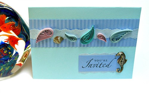 quilled seashell party invitation with glass paperweight containing glass fish