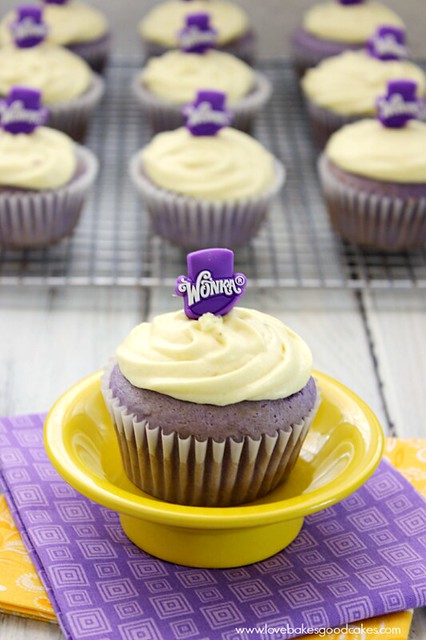Grape Cupcake with Banana Icing in yellow bowl. Cupcakes on cooling rack behind.