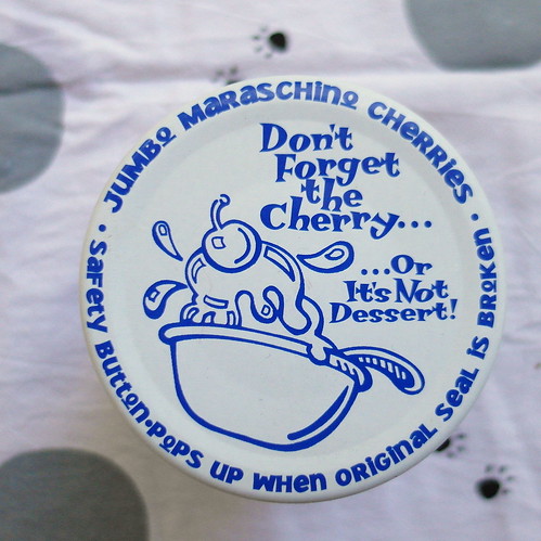 The lid of a jar of maraschino cherries. Text reads "Don't forget the cherry...or it's not dessert!"