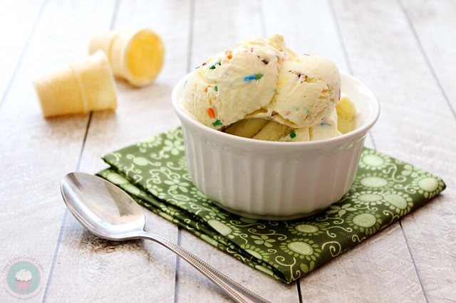 Lemon Funfetti Ice Cream in a white bowl with a spoon and two ice cream cone shells.