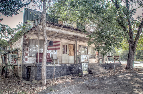 old trees usa building abandoned architecture rural vintage georgia store nikon closed unitedstates antique decay flag south country rusty americanflag architectural gasstation business southern faded adobe weathered boardedup generalstore frontporch derelict mica shady decayed smalltown gaspump outofbusiness lightroom countrystore fillingstation cherokeecounty ballground stancilsstore d7000 stgrundy