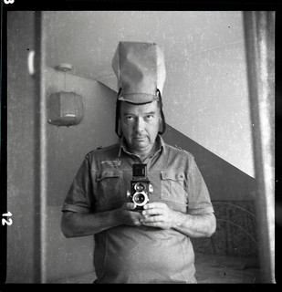 reflected self-portrait with Ricoh Super 44 camera and tall hat
