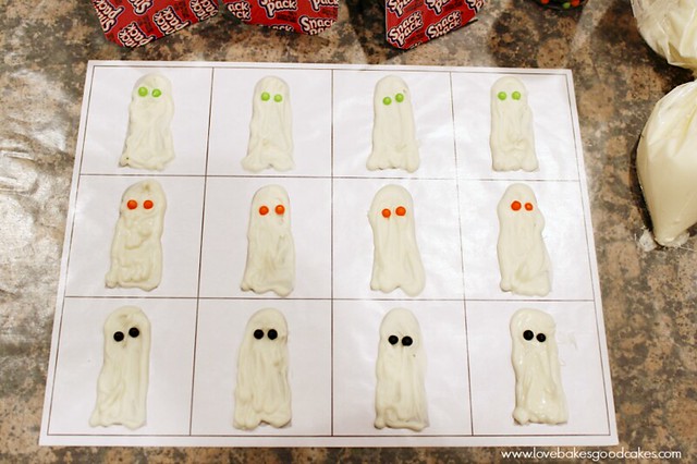 Ghost in the Graveyard Halloween Snack Pack Pudding Cup candy ghosts on parchment paper.