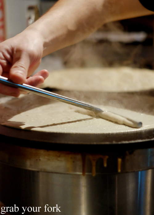 Spreading the crepe batter with a metal dowel at Creperie Le Triskel, Melbourne