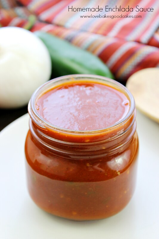 Homemade Enchilada Sauce in a glass jar on a plate.