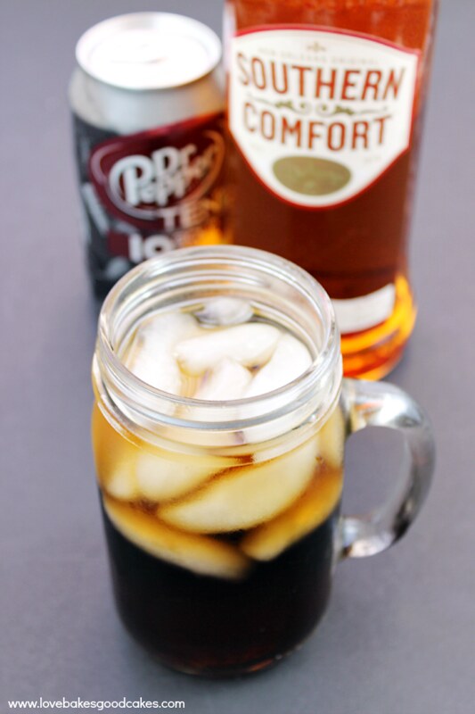 The Southern Doctor Cocktail in a glass jar with a can of Dr. Pepper and a bottle of Southern Comfort.