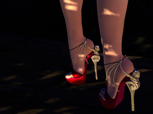 Image Description: Closeup of shoes in a dappled darkness with gargoyles as heels.
