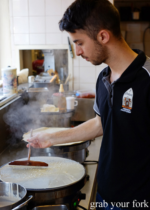 Smoothing out the crepe batter with a wooden dowel at Breizoz French Creperie, Fitzroy