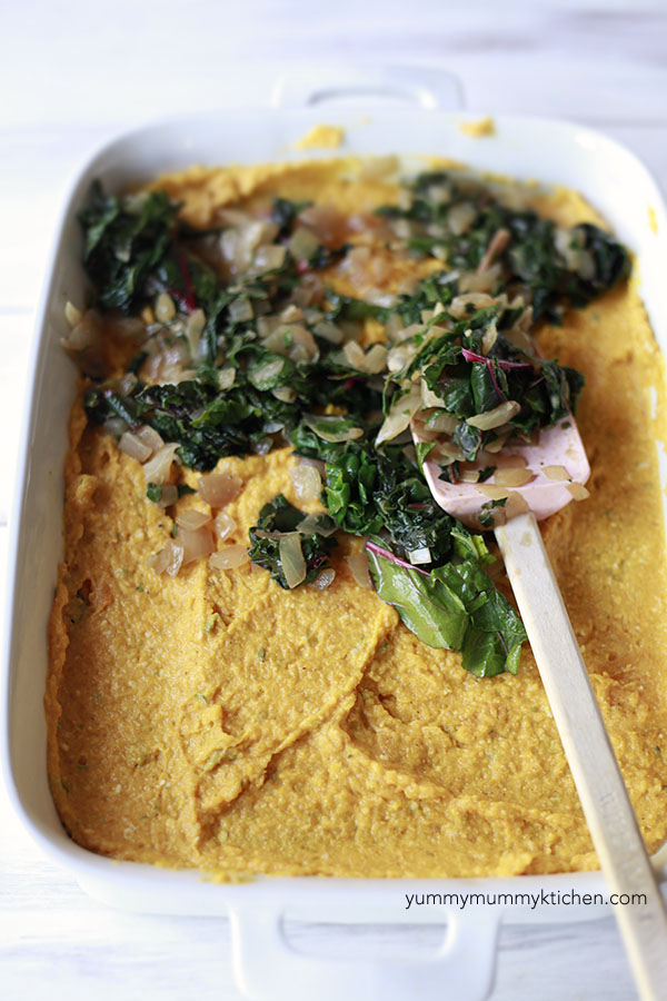 Chard and onions are layered with pumpkin puree to assemble a vegetarian pumpkin lasagna. 