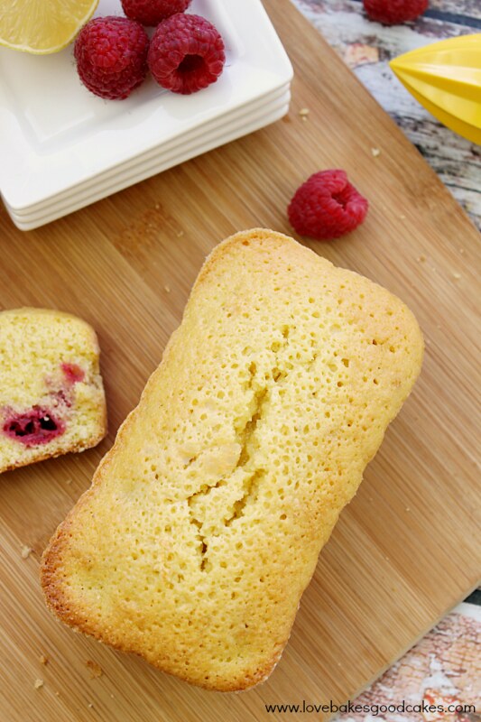 Dorie Greenspan's Cornmeal and Berry Cakes on cutting board with fresh raspberries.